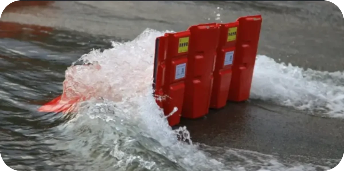 Red modular flood barrier holding back a surge of water